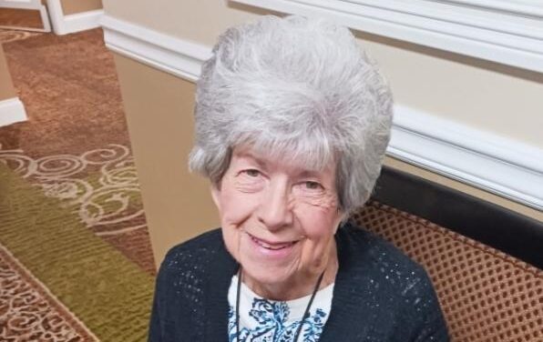 Senior resident sitting in a chair and smiling