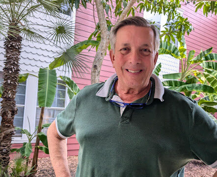 Senior resident smiling by a tree