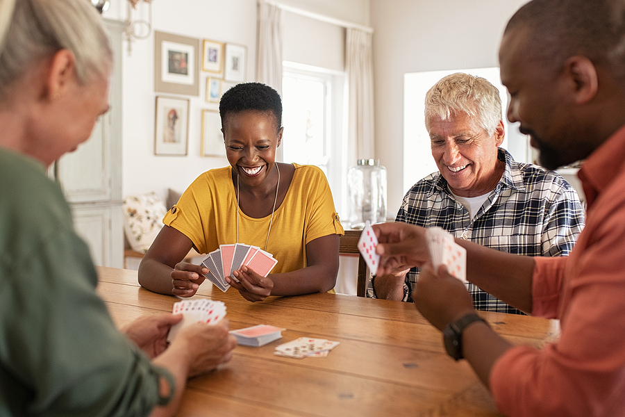 4 adults playing cards together
