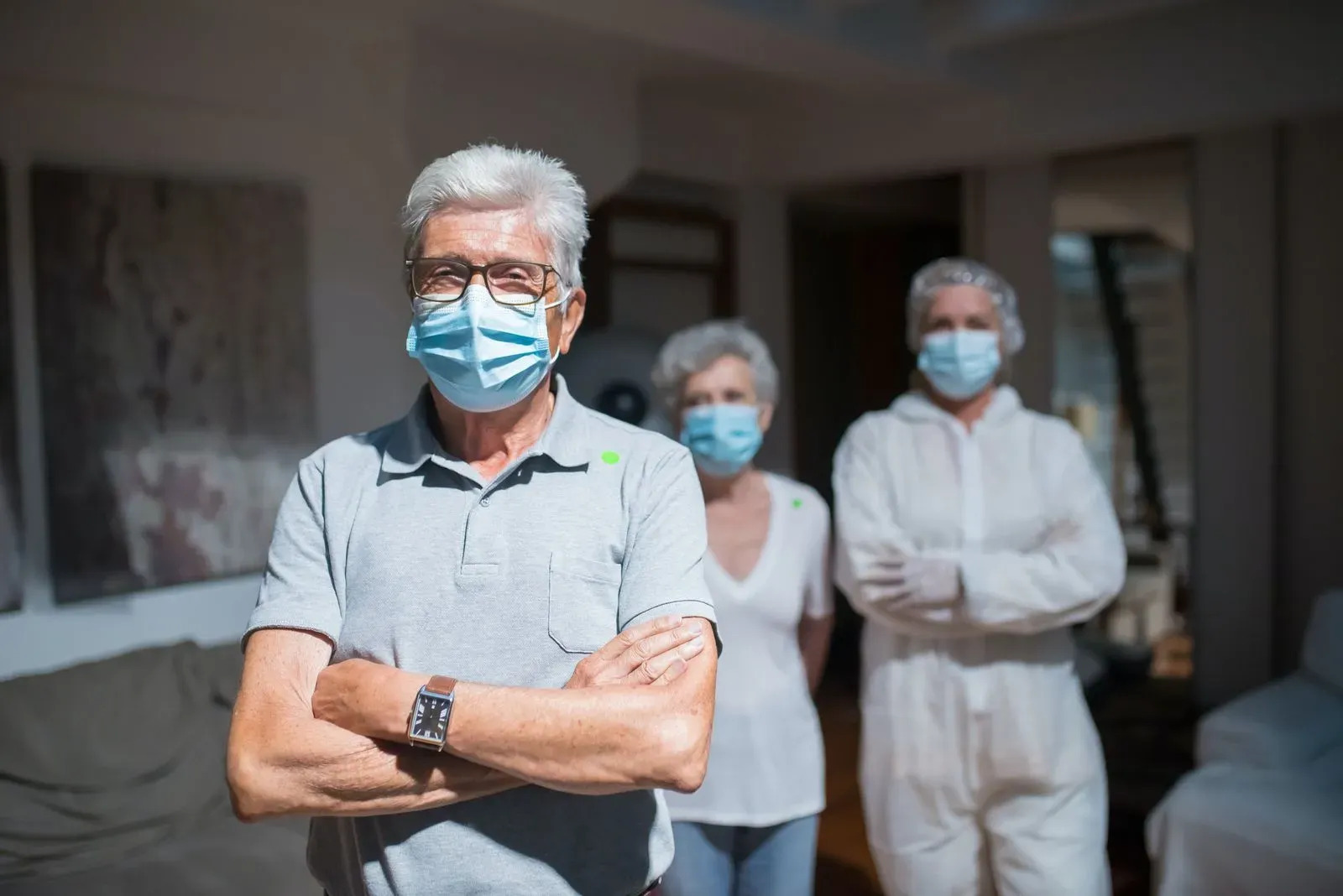 Senior standing in front of nurse, all of them wearing a mask